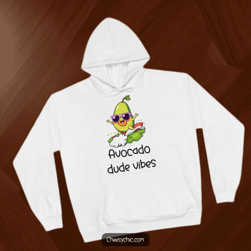 Funny hoodie showing a cheerful avocado with sunglasses surfing a big wave made of guacamole, exuding coolness and joy.