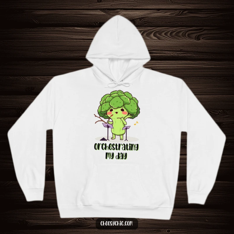 Funny hoodie featuring an adorable anthropomorphic broccoli conducting an invisible orchestra with a twig, radiating musical energy.