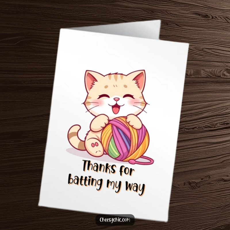 Funny Free Printable Thank You Card: Cat happily batting a colorful ball of yarn, conveying playful thanks.