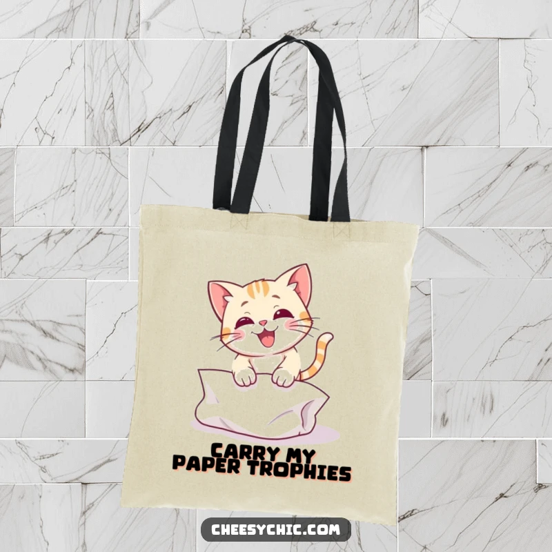 Funny tote bag featuring a cute cat character hilariously pouncing with full force on a crinkled paper ball.