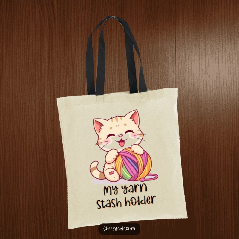 Funny tote bag featuring a cute cat character happily batting at a vibrant, multi-colored ball of yarn.